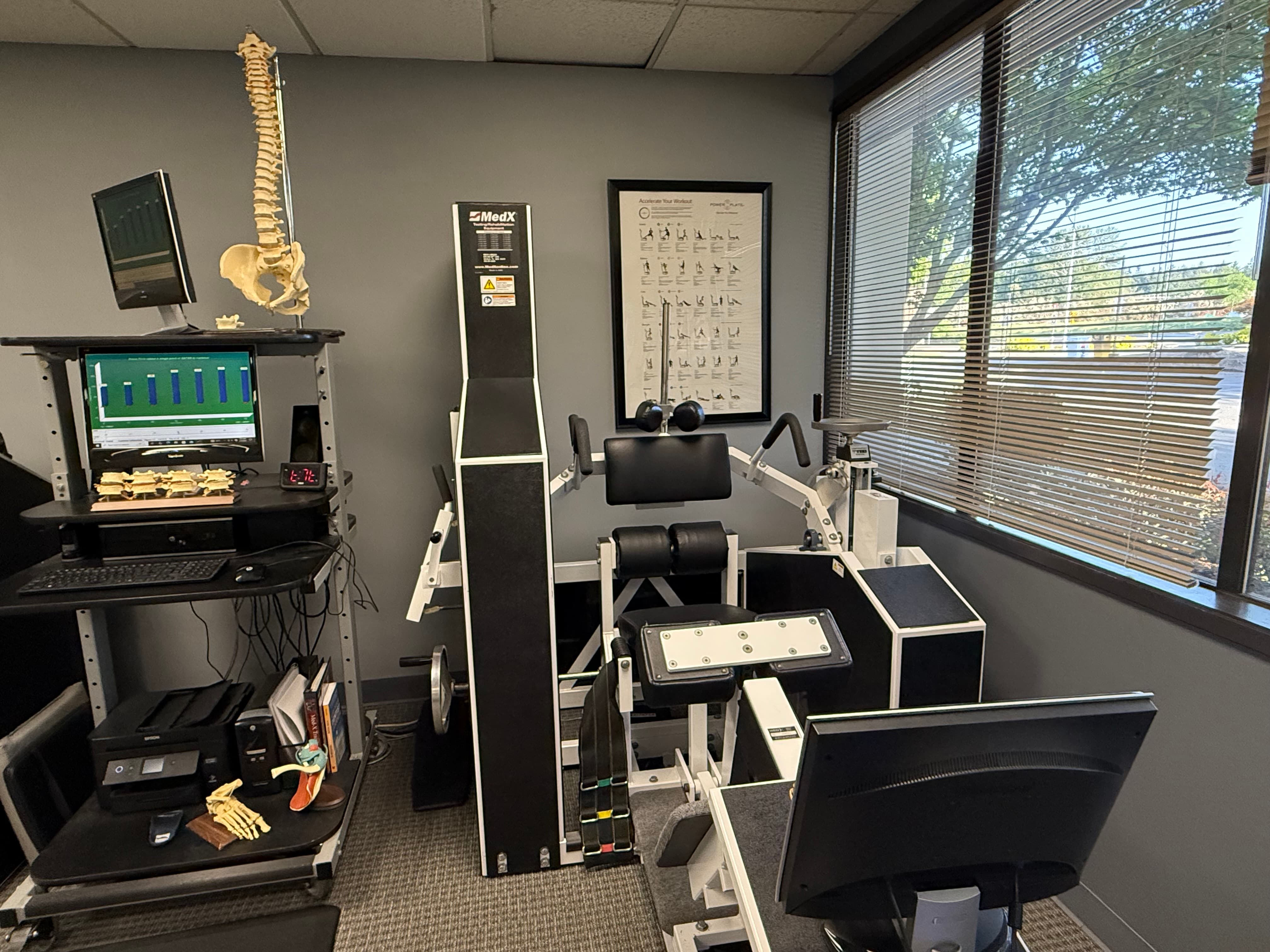 MedX Lumbar Extension Machine at Fix Back & Neck Pain in Redmond, WA — pelvic restraint and progressive resistance for isolated lumbar strengthening.