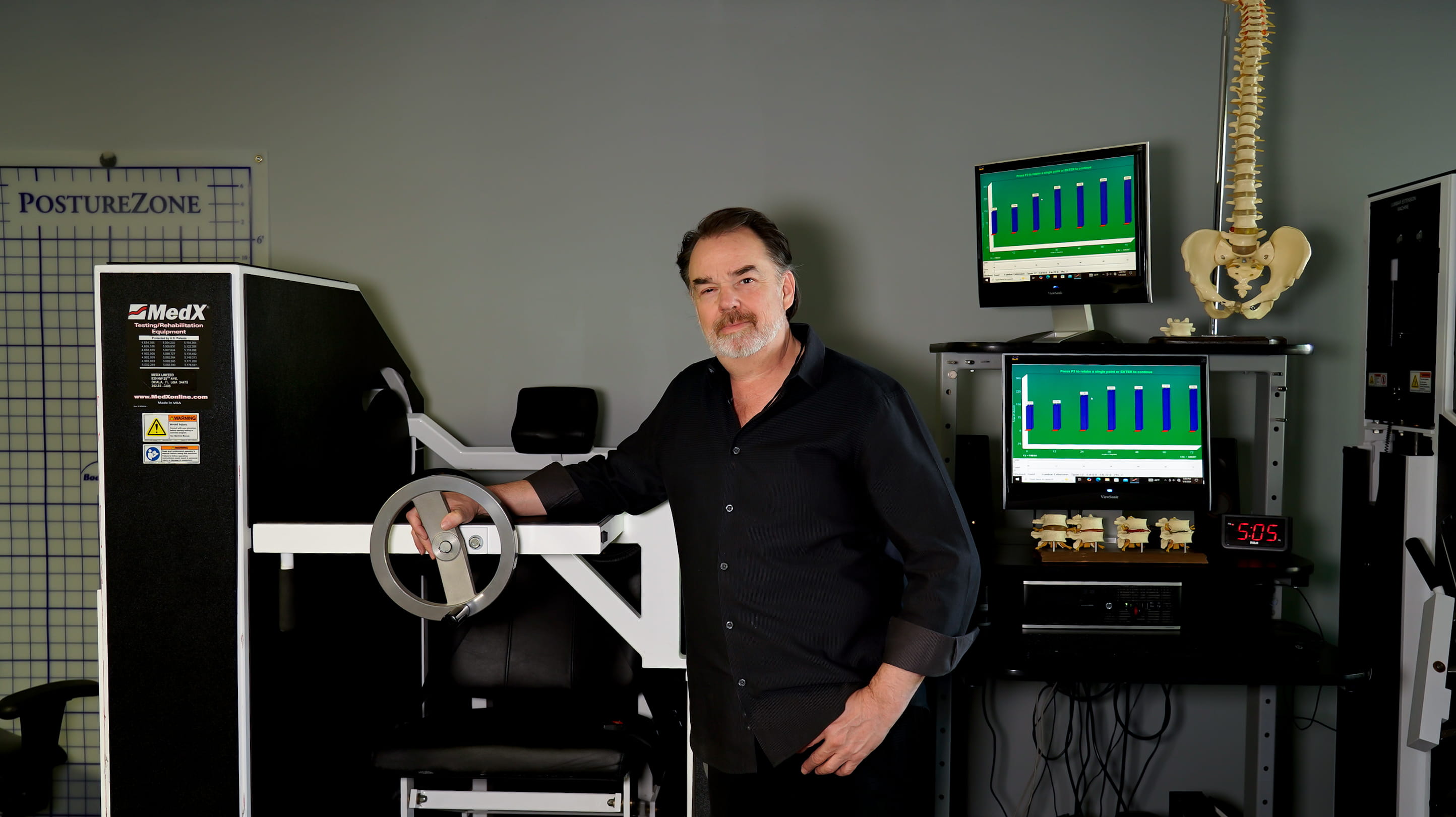 Trent Shuford, LMT, demonstrating the MedX cervical rehabilitation machine at Fix Back & Neck Pain in Redmond, WA.